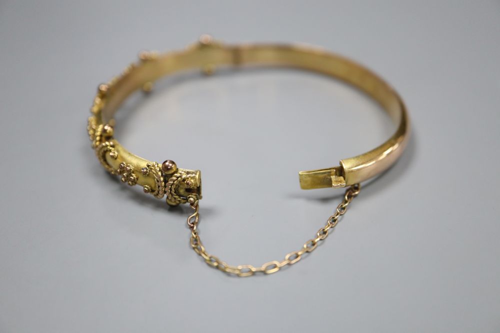 A late Victorian 9ct gold hinged bangle, gross 9.1 grams, with engraved initials.